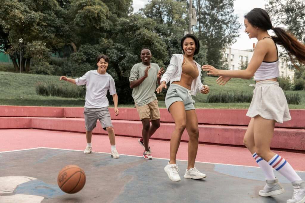 Four girls playing basketball on the court, wearing white shorts, in action