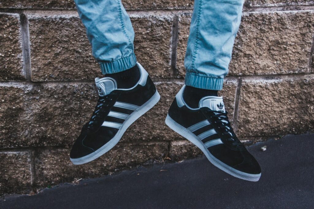 photography of a person wearing adidas gazelle