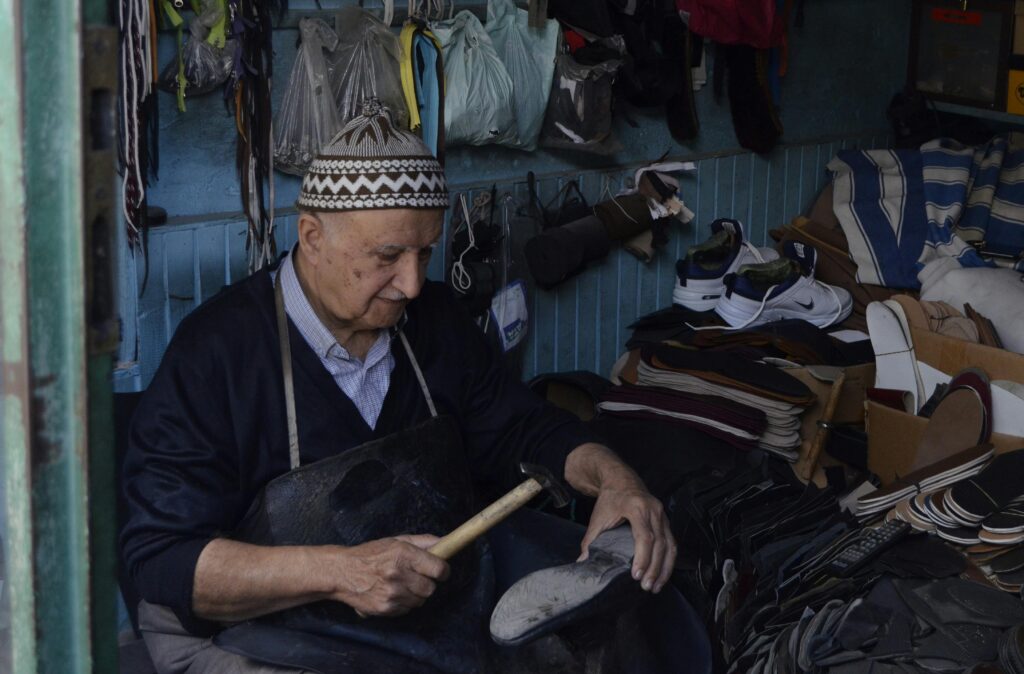 Person cleaning a suede shoe with a soft brush and cleaner.