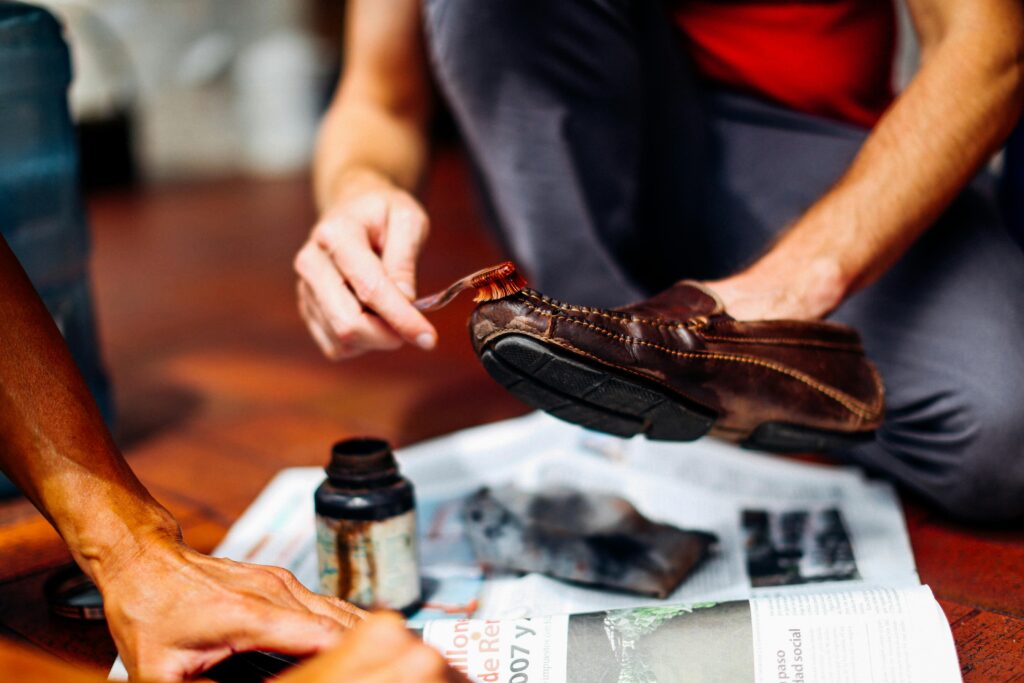 Shoes being hand-washed with a toothbrush and baking soda mixture